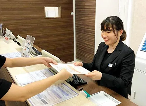 買取受付でお客様に伝票を渡すスタッフ